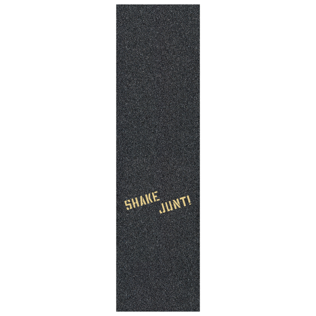 A single long rectangular black grip tape strip with a textured granular surface and the words 'SHAKE JUNT!' printed near the bottom in a metallic gold font, shown on a plain white background.