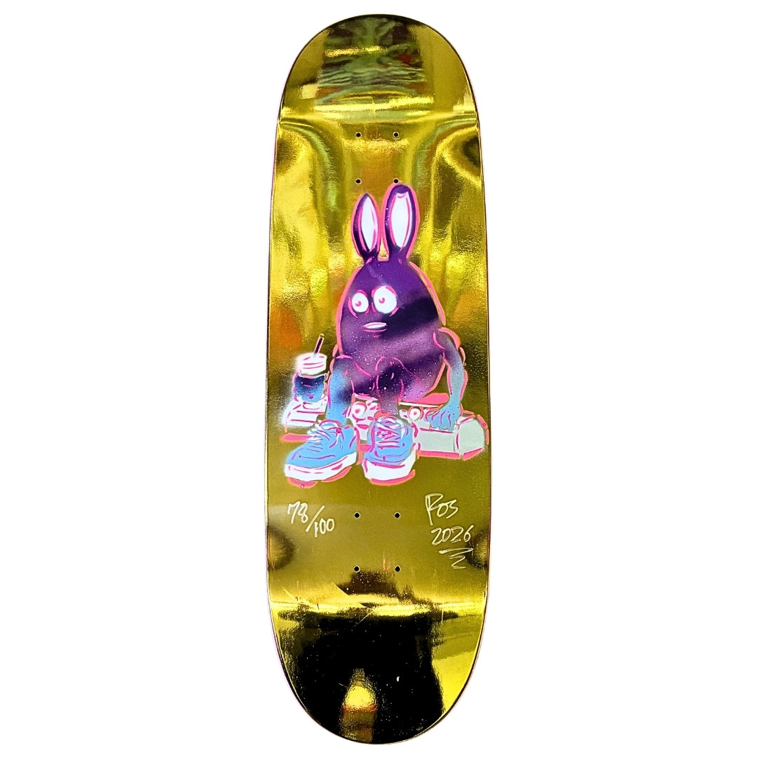 Skateboard deck with a colorful rabbit design on a gold background