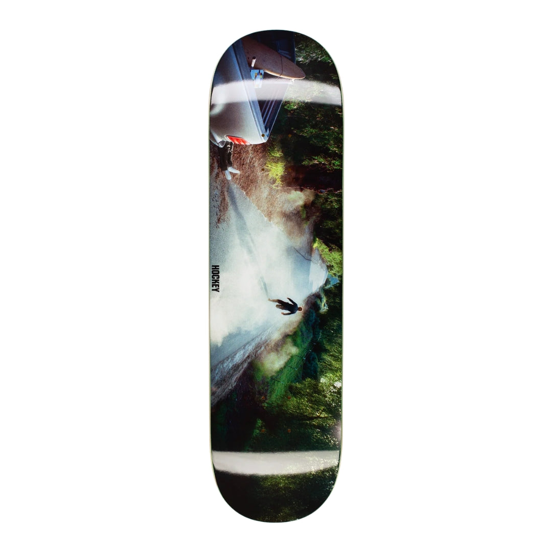 Skateboard deck with a graphic design of a person on a mountain on a white background