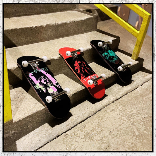 Three skateboard decks on concrete steps with a yellow railing.