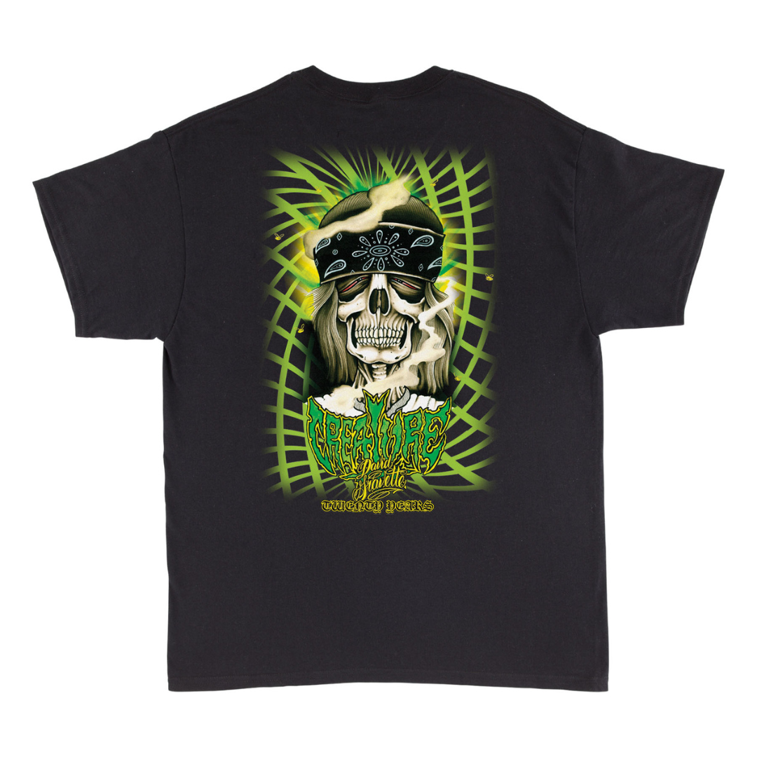 A black short-sleeve graphic t-shirt featuring a large back print of a skull wearing a bandana and sunglasses, surrounded by green palm leaves and the text 'BURNING JEFFERSON' and 'SOMETHING BETTER'.