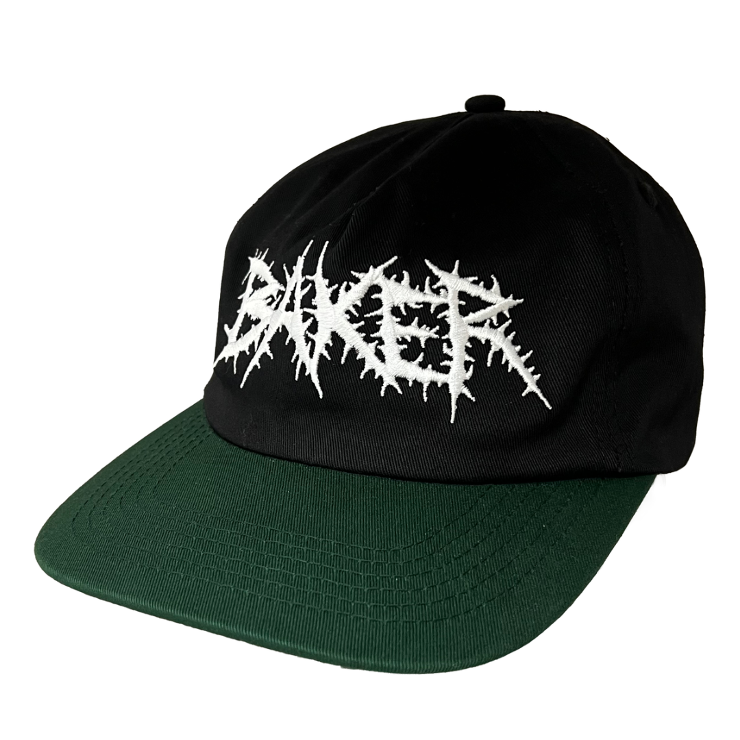 A black and dark green snapback cap featuring a white spiky metal-style logo embroidered on the front, shown against a plain white background.